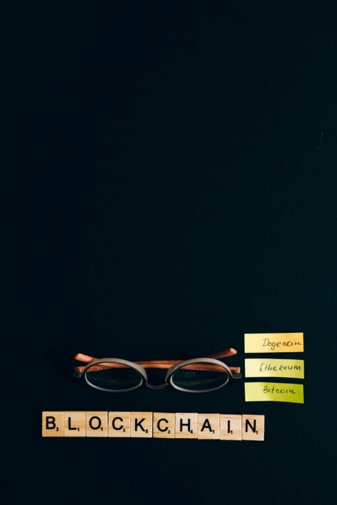 tokenized assets blockchain glasses tiles Scrabble tiles spelling "BLOCKCHAIN".